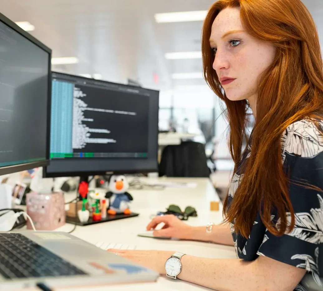 Engineer working at a computer with code on the screen
