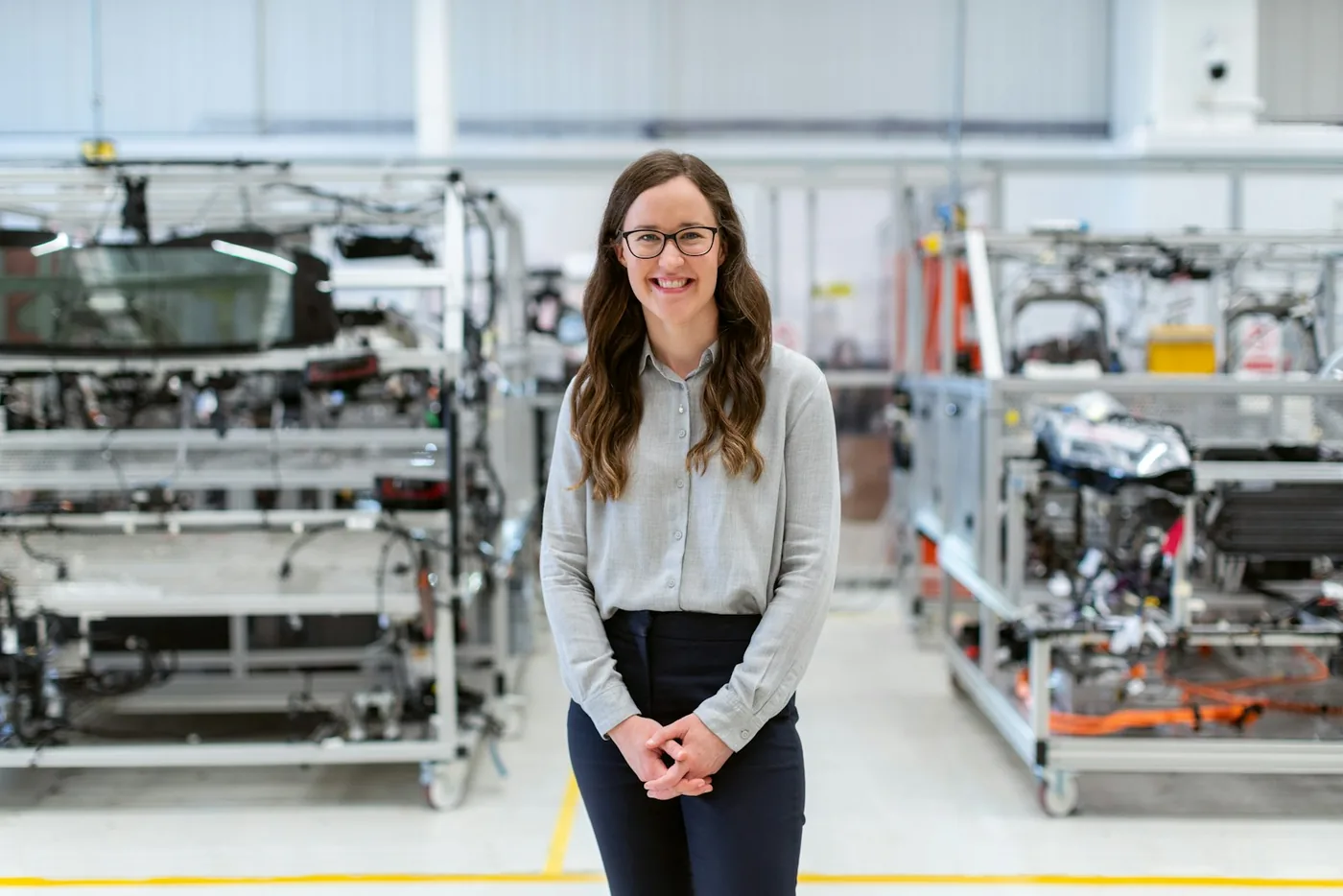 Smiling engineer standing on a manufacturing floor