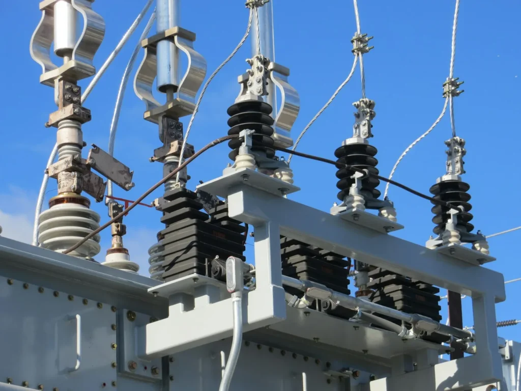 Electrical insulators on a power transformer against a blue sky